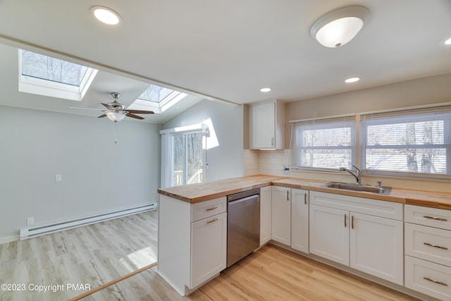 kitchen with white cabinets, dishwasher, a baseboard radiator, butcher block counters, and a sink