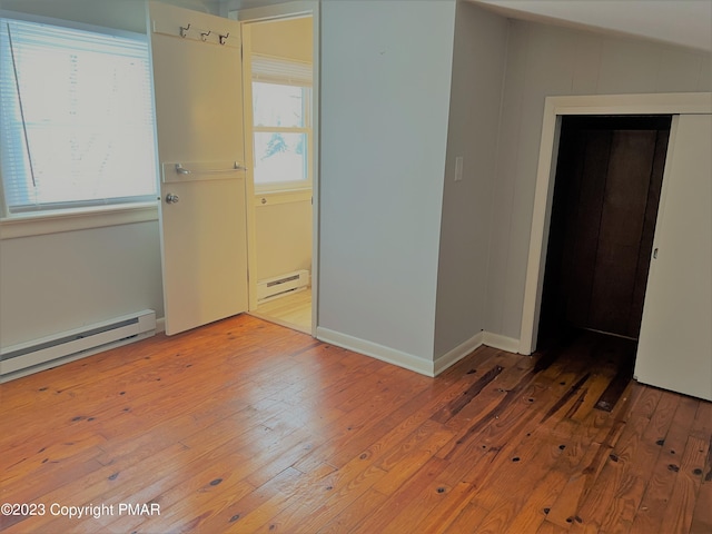 spare room with baseboards, a baseboard radiator, a baseboard heating unit, and hardwood / wood-style floors