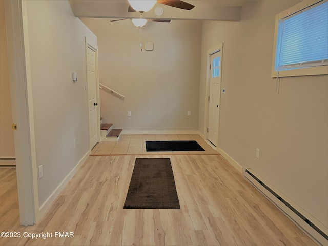 foyer featuring baseboards, stairway, wood finished floors, a healthy amount of sunlight, and a baseboard heating unit