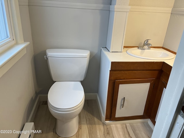 bathroom with toilet, baseboards, wood finished floors, and vanity