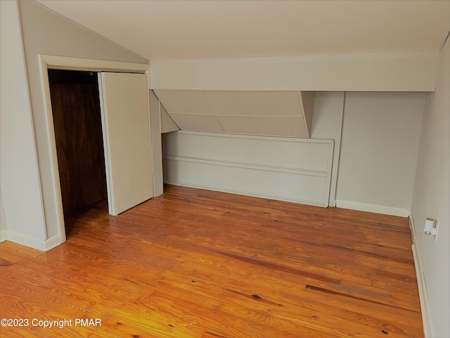 interior space with vaulted ceiling, light wood-style flooring, and baseboards