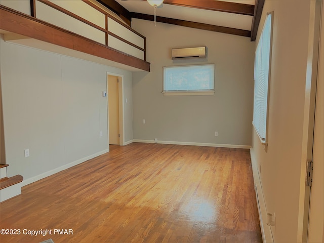 empty room with baseboards, lofted ceiling with beams, a baseboard radiator, wood finished floors, and a wall mounted air conditioner