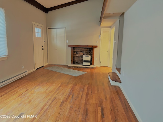 unfurnished living room with a fireplace, baseboard heating, wood finished floors, beamed ceiling, and baseboards