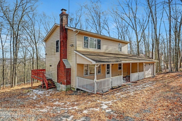 view of front of house featuring an attached garage, covered porch, and a chimney