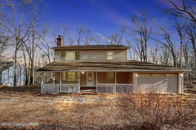 view of front of home featuring a porch, a garage, and a chimney