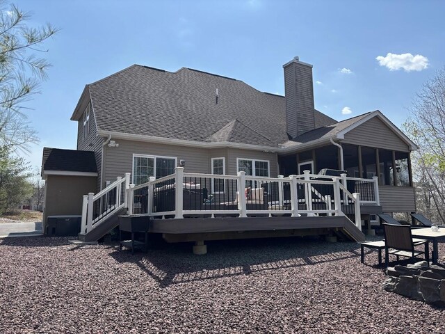 389 Joanne Ct, Bartonsville, PA 18321 - back of house featuring a chimney, a sunroom, a wooden deck, and roof with shingles