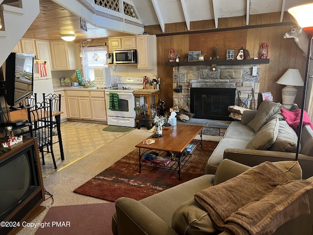 living room featuring wooden walls, beamed ceiling, and a stone fireplace