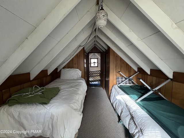 bedroom with carpet floors, wood walls, and vaulted ceiling