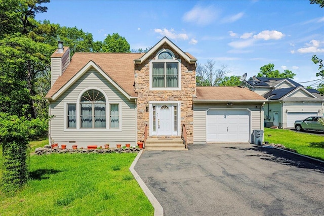 349 Mallard Ln, Bushkill, PA 18324 - view of front of property featuring a garage, asphalt driveway, a chimney, a front lawn, and stone siding