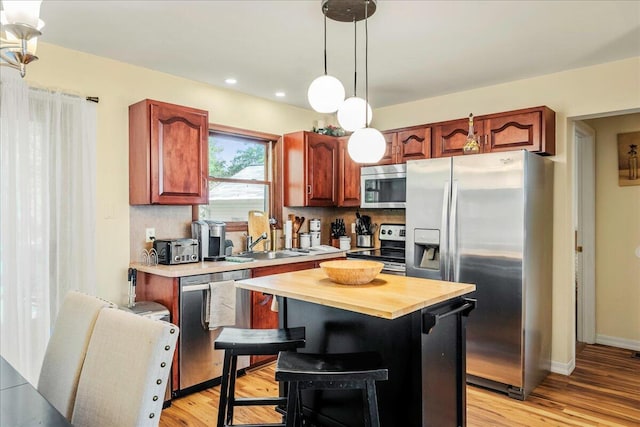 349 Mallard Ln, Bushkill, PA 18324 - kitchen with appliances with stainless steel finishes, hanging light fixtures, light wood-style floors, a center island, and wooden counters