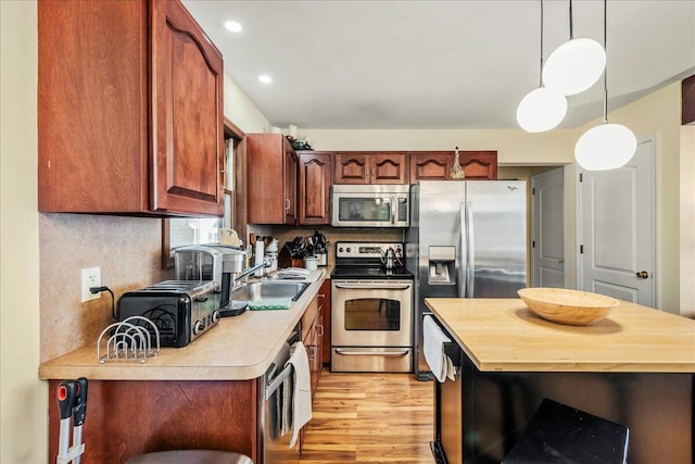 349 Mallard Ln, Bushkill, PA 18324 - kitchen featuring appliances with stainless steel finishes, a sink, butcher block counters, light wood-style flooring, and pendant lighting