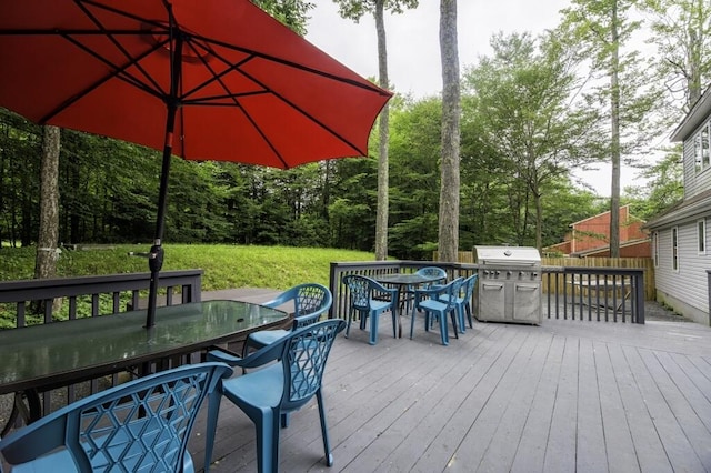 deck featuring outdoor dining space and a yard
