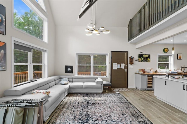 325 Chestnut Rd, East Stroudsburg, PA 18302 - living room with high vaulted ceiling, beverage cooler, a chandelier, light wood-style floors, and healthy amount of natural light