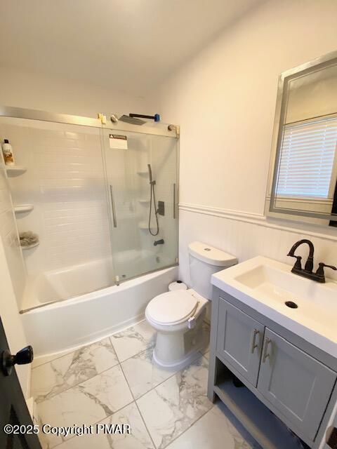 full bathroom with toilet, marble finish floor, enclosed tub / shower combo, and vanity