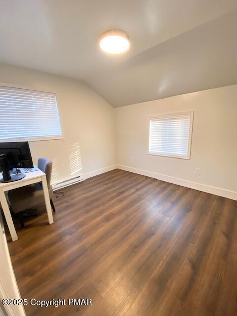 office space featuring vaulted ceiling, baseboards, and dark wood finished floors