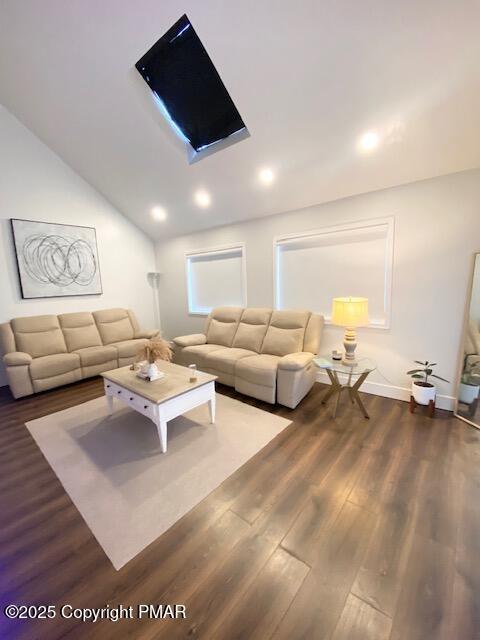 unfurnished living room featuring lofted ceiling, baseboards, recessed lighting, and wood finished floors