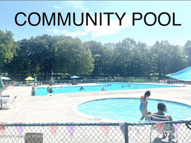 community pool with fence and a patio