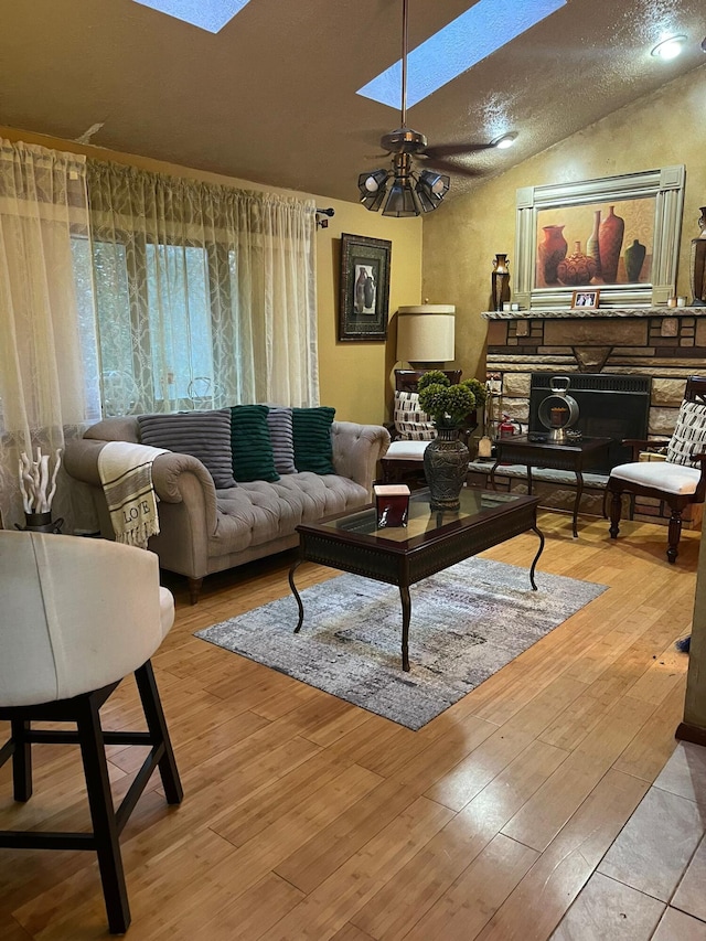 5112 Navajo Pl, Tobyhanna, PA 18466 - living area featuring a skylight, lofted ceiling, wood-type flooring, a fireplace, and a ceiling fan