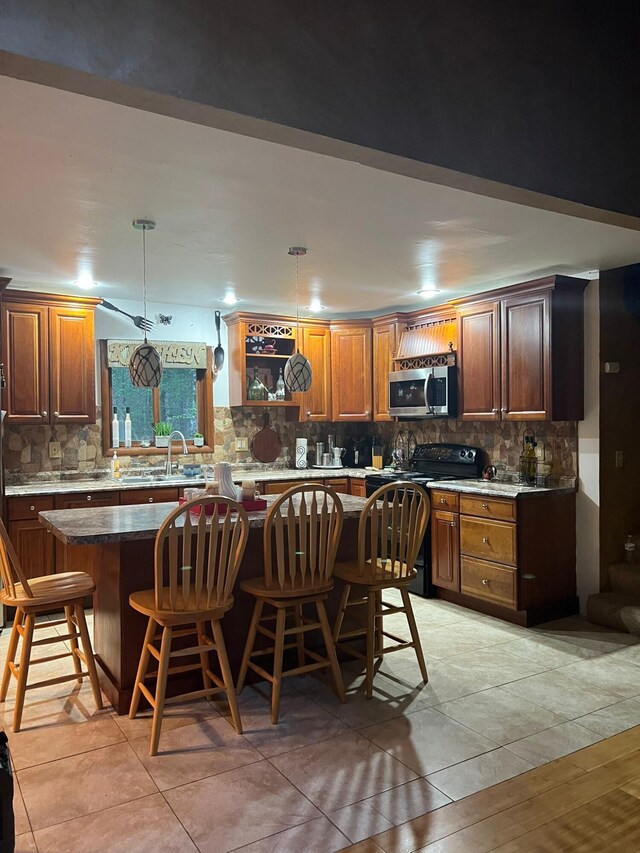 5112 Navajo Pl, Tobyhanna, PA 18466 - kitchen with range with electric stovetop, stainless steel microwave, tasteful backsplash, and a kitchen breakfast bar