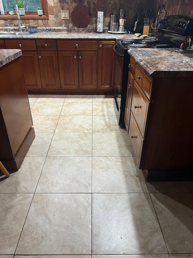 5112 Navajo Pl, Tobyhanna, PA 18466 - kitchen with black range with electric stovetop, tasteful backsplash, light tile patterned floors, and stone countertops