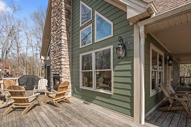 wooden deck with a porch and area for grilling