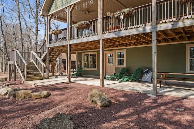 rear view of house with a deck, stairs, and a patio