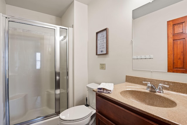 full bath with a shower stall, vanity, and toilet