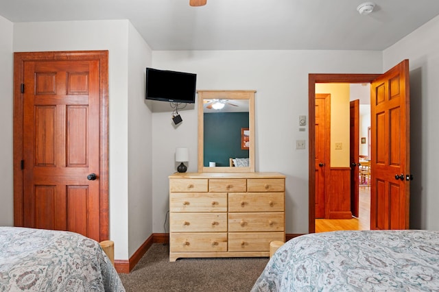 bedroom with light colored carpet, a ceiling fan, and baseboards