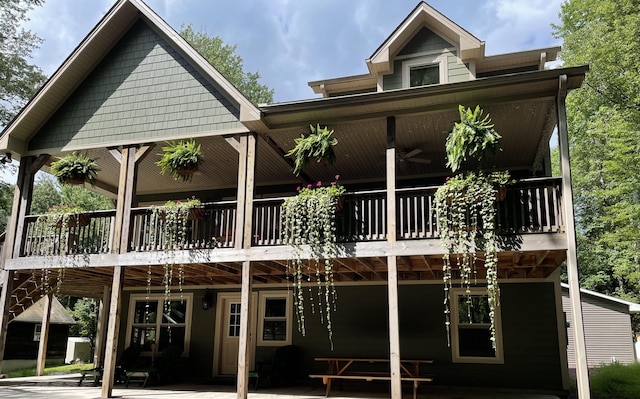 rear view of property with a ceiling fan and a patio