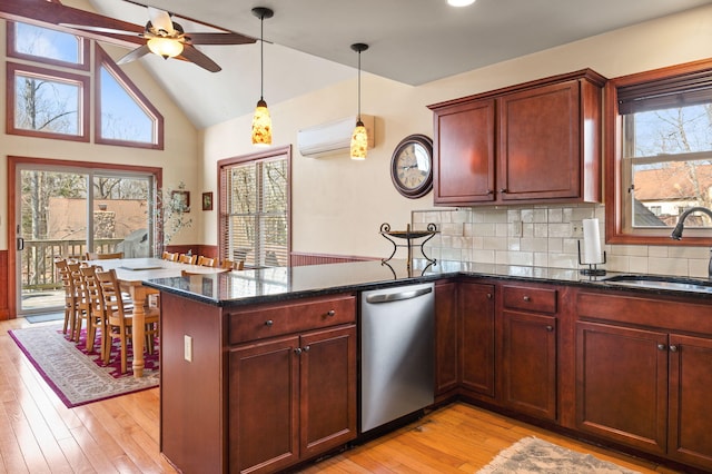 kitchen with a wall mounted air conditioner, a ceiling fan, a sink, a peninsula, and light wood finished floors