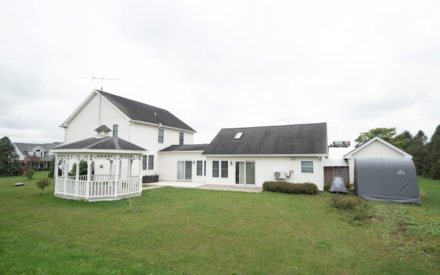 back of property featuring a gazebo, a patio area, and a lawn