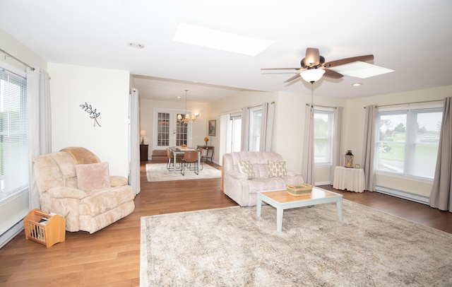 living area featuring wood finished floors, a healthy amount of sunlight, and a skylight