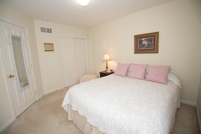 bedroom featuring a closet, visible vents, light colored carpet, and baseboards