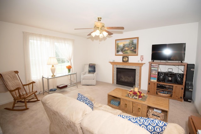 carpeted living room with a fireplace with flush hearth and ceiling fan