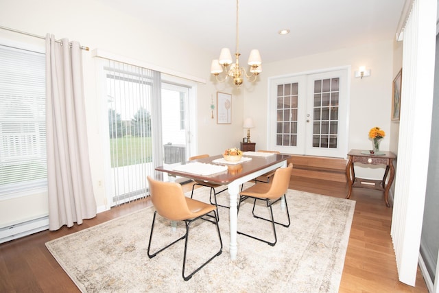 dining area featuring wood finished floors, recessed lighting, french doors, and a chandelier