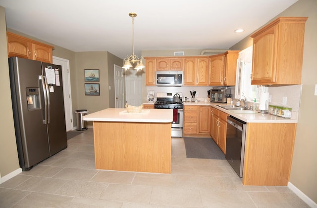 kitchen with visible vents, a kitchen island, light countertops, appliances with stainless steel finishes, and a sink