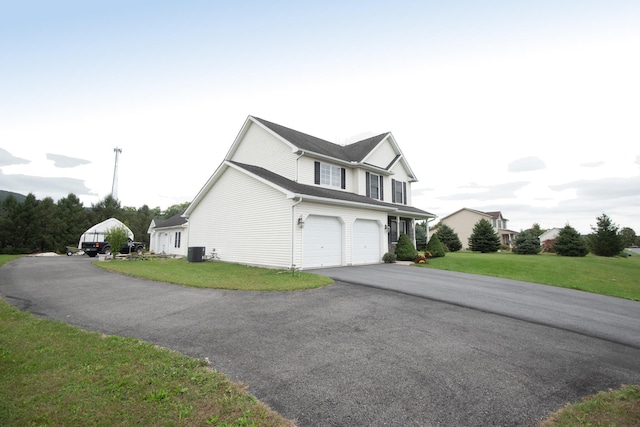 view of front facade featuring aphalt driveway, central AC unit, a garage, and a front yard