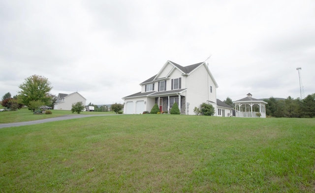 view of front facade featuring a gazebo, driveway, an attached garage, and a front yard