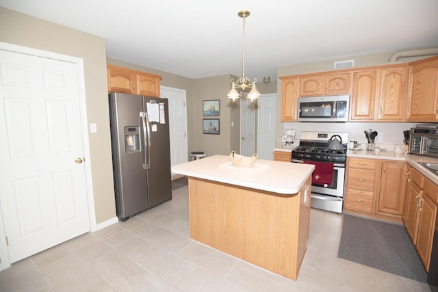 kitchen with visible vents, light brown cabinetry, a center island, stainless steel appliances, and light countertops