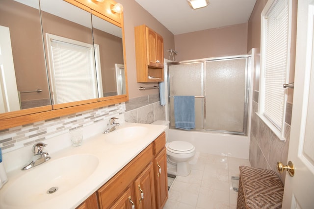 full bath featuring a sink, toilet, tile walls, and double vanity