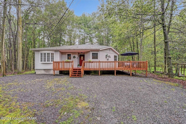 view of front facade featuring a deck and a forest view