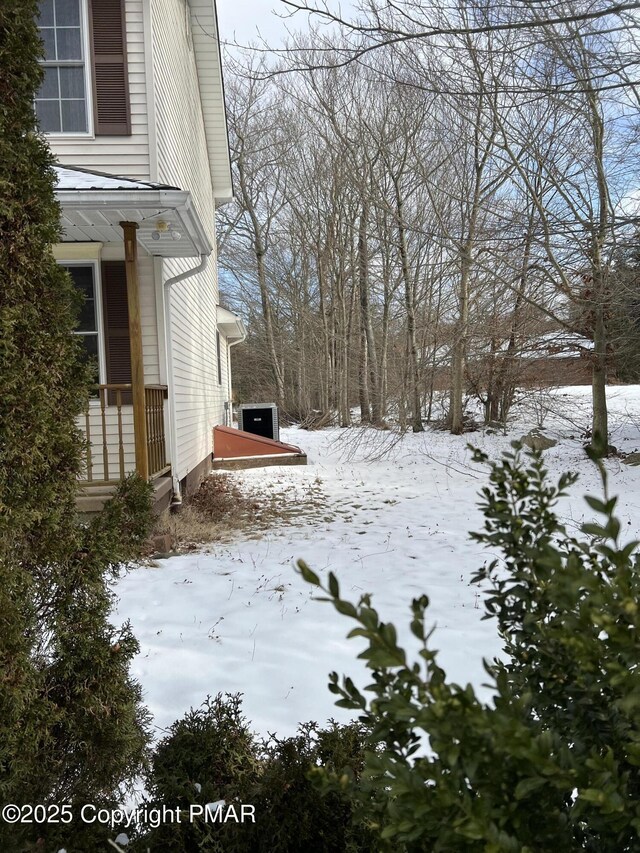 yard covered in snow featuring central AC