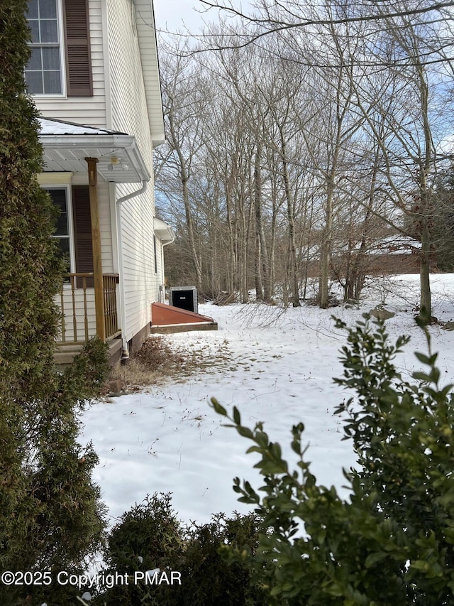 yard covered in snow featuring central AC unit