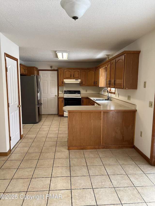 kitchen with under cabinet range hood, a peninsula, a sink, black electric range, and stainless steel fridge