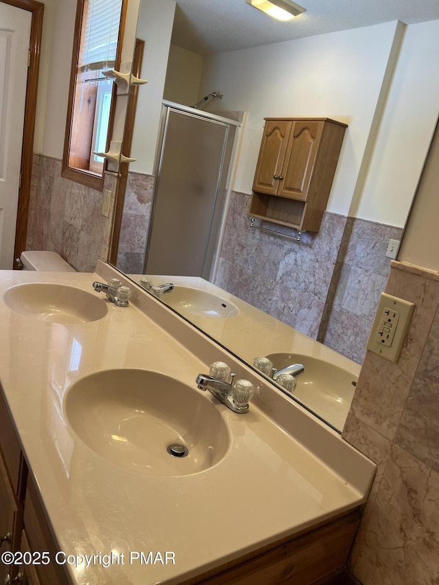 bathroom with vanity, tile walls, and walk in shower