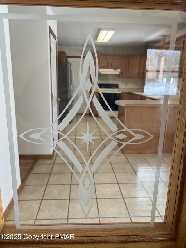 interior space with stove, tile patterned floors, and stainless steel refrigerator