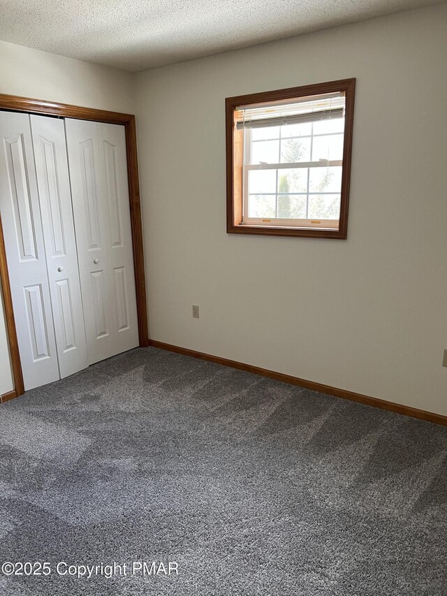 unfurnished bedroom with a closet, carpet flooring, and a textured ceiling