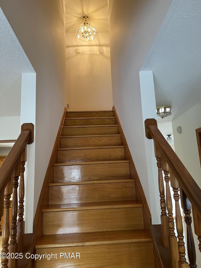 stairs featuring a textured ceiling