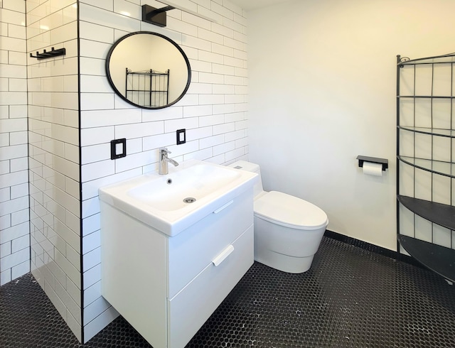 bathroom featuring tile walls, tasteful backsplash, toilet, vanity, and tile patterned floors