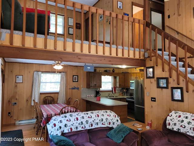 21 Cherry Ct, Clifton Township, PA 18424 - living area featuring wood walls, light wood-style flooring, baseboard heating, and stairs